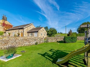 A stone house with a garden, a slide, and a stone wall. - 2 Bed in Huby (oc-79166) (Weeton)