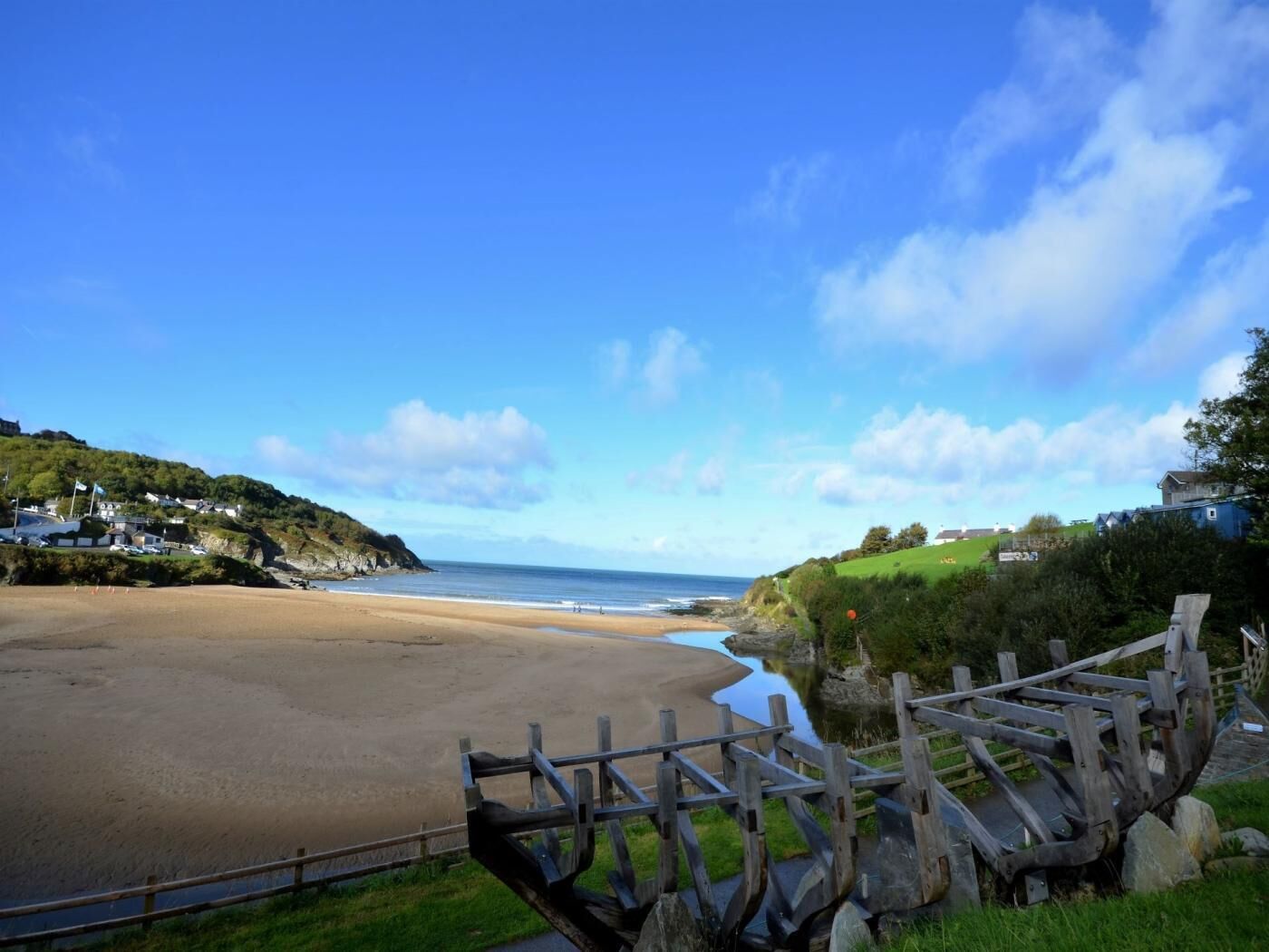A beach with a wooden fence and a clear view of the sea.