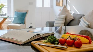 Une cuisine moderne avec une table à manger, un livre et des légumes frais.
