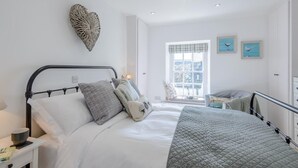 Une chambre à coucher avec un lit, une table de chevet et une fenêtre donnant sur un beau paysage.