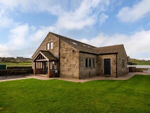A stone building with a gabled roof, a small porch, and a door. - 6 Bed in Scammonden (oc-79287) (Huddersfield)