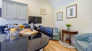 A modern kitchen with a dining area, a flat-screen TV, and a sofa. - 1 Bed in Lewes (oc-79182) (Beddingham)
