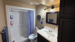Ein Badezimmer mit Badewanne, Toilette, Waschbecken und Spiegel.