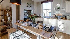 Eine moderne Küche mit Essbereich, Holzregalen und einem großen Fenster.