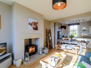 Una sala de estar acogedora con chimenea, un comedor y una cocina.