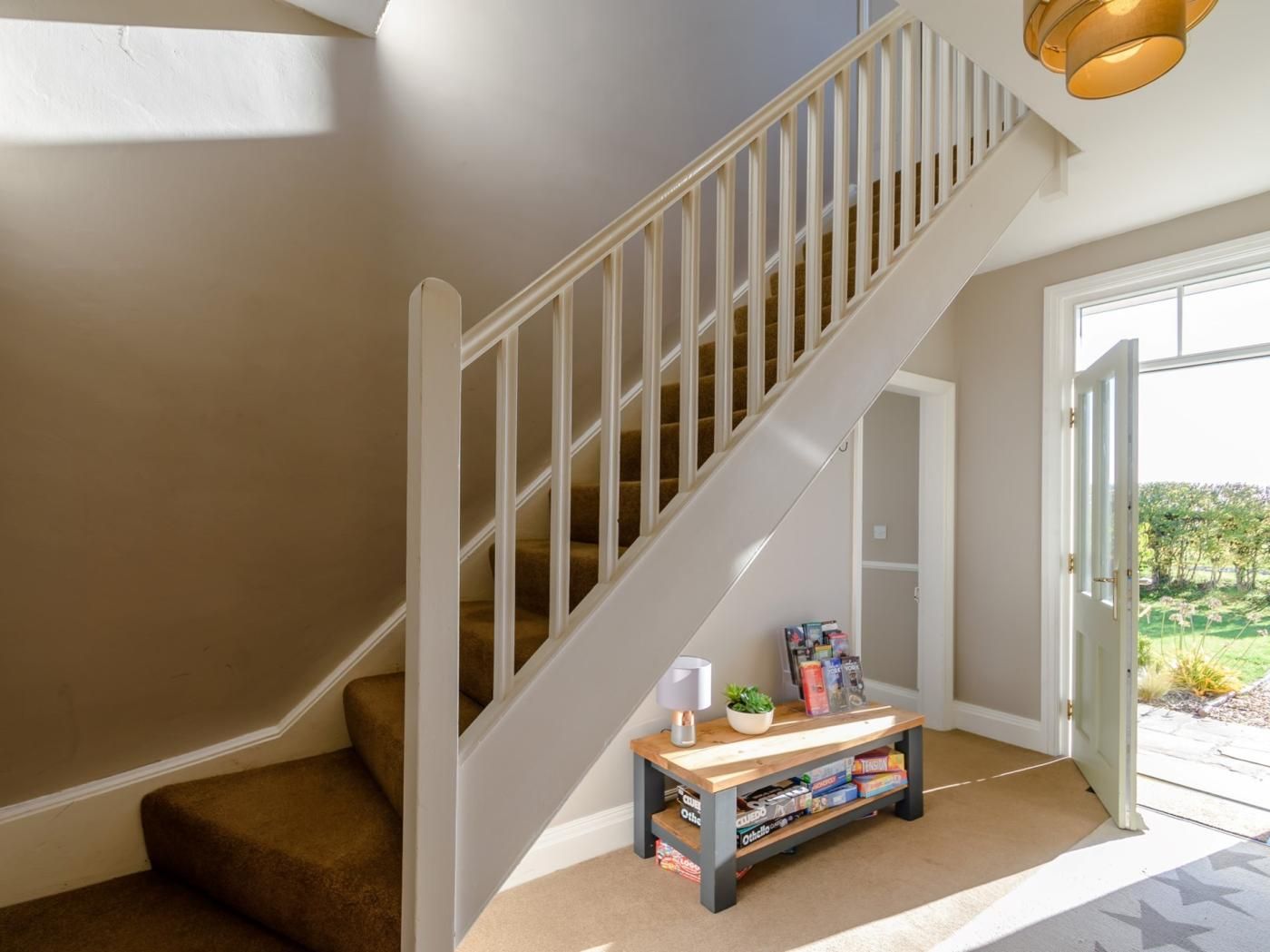 A staircase with a white railing leading to a landing.