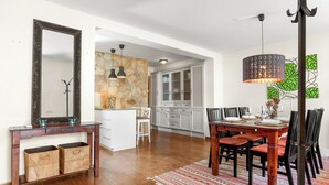 Un comedor con mesa de madera, sillas y un tapete estampado.