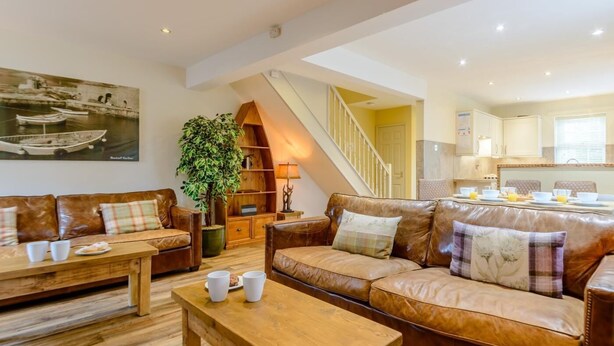A living room with a sofa, a coffee table, and a bookshelf. - 3 Bed in Chathill (oc-79566) (Beadnell)