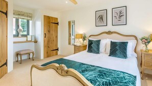 A bedroom with a bed, a wooden wardrobe, a desk, a chair, a ceiling fan, and two framed pictures on the wall. - 2 Bed in Newton Tracey (oc-80381) (Newton Tracey)