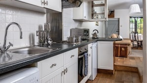 A modern kitchen with white cabinetry, stainless steel appliances, and a black countertop. - 2 Bed in Brecon (oc-bn016) (Talybont-on-Usk)