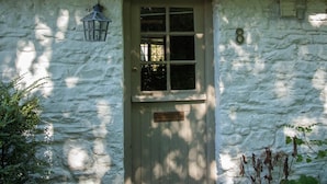 A white stone building with a wooden door and a window, number 8 on the wall. - 2 Bed in Brecon (oc-bn016) (Talybont-on-Usk)