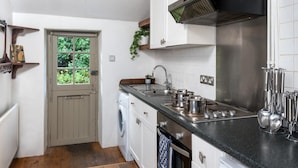 A compact kitchen with a washing machine, a sink, and a stove. - 2 Bed in Brecon (oc-bn016) (Talybont-on-Usk)