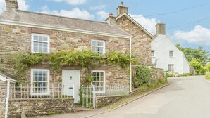 A stone building with a white door, a small white fence, and a clear sky. - 2 Bed in Crickhowell (oc-bn023) (Llangynidr)