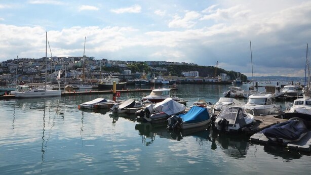 A marina with boats docked, a cityscape in the background, and a clear sky. - 2 Bed in Brixham (oc-80453) (Brixham)