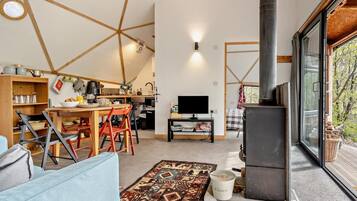 Un intérieur moderne comprenant un coin repas, une cuisine, un espace de vie et une grande fenêtre.