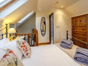 A bedroom with a bed, a wooden dresser, a mirror, and a skylight. - 1 Bed in Ashbourne (oc-80376) (Fenny Bentley)