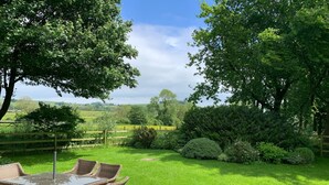 A garden with a table and chairs, surrounded by greenery and a fence. - 2 Bed in Ashbourne (oc-80458) (Parwich)