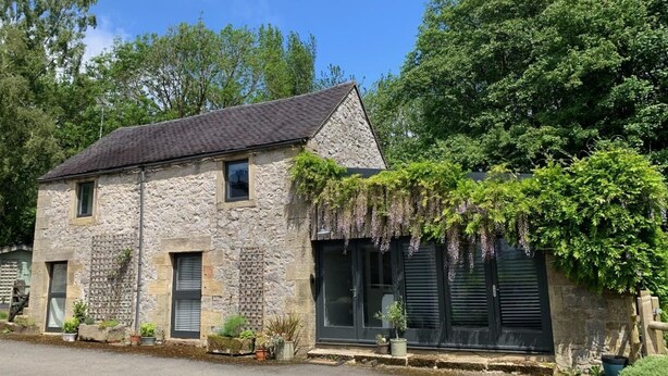 A stone building with a sloped roof, a window, and a door. - 2 Bed in Ashbourne (oc-80458) (Parwich)