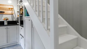 A staircase with white railings leading to a landing with a kitchen area. - 2 Bed in Ashbourne (oc-80458) (Parwich)