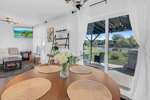 A dining area with a table, placemats, and a vase of flowers. - 2 bedroom Getaway/Lake St. Claire, Canada/kayak (Belle River)