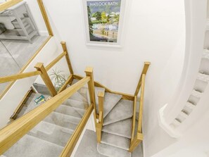 A spiral staircase with wooden handrails and carpeted steps.