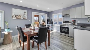 A modern kitchen with white cabinets, a stainless steel oven, and a granite countertop.