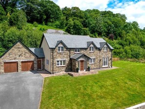 A stone house with a driveway and a well-maintained lawn. - 5 Bed in Brecon (oc-bn318) (Bwlch)