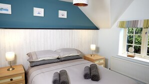 Een slaapkamer met een bed, twee nachtkastjes, een raam met uitzicht en een plafondlamp.