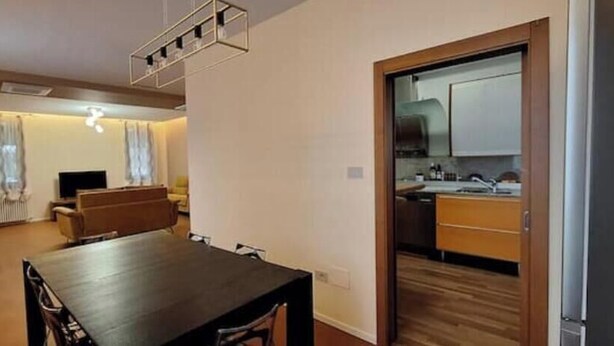 A compact living space with a dining table, a sofa, and a kitchenette. - Corina's Place Bologna Villa (Bologna)