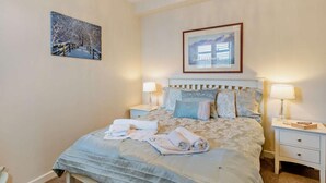 A bedroom with a bed, two bedside tables, a nightstand, a framed picture, and a ceiling light fixture. - 2 Bed in Keswick (oc-80515) (Keswick)