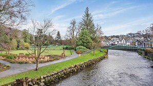 A river with a stone wall and a green bridge. - 2 Bed in Keswick (oc-80515) (Keswick)