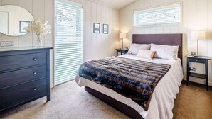 A bedroom with a bed, dresser, bedside tables, a mirror, and a window with blinds. - 2 Bed in Wigton (oc-80563) (Caldbeck)