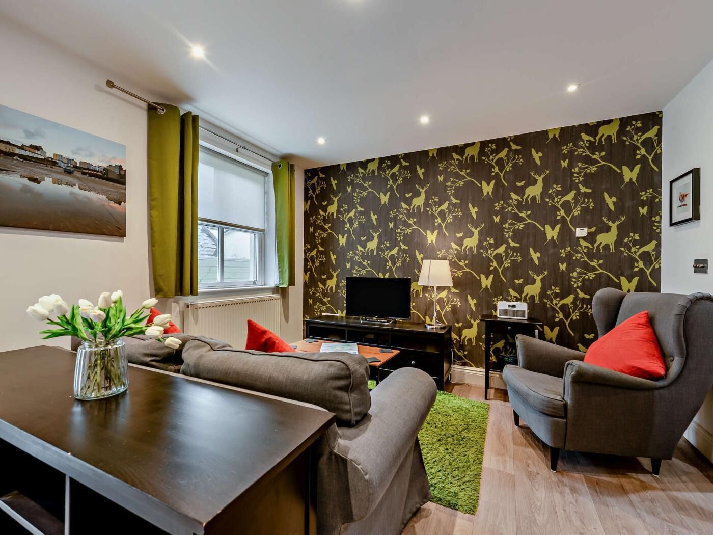 Een moderne woonkamer met een bank, fauteuil en televisie.