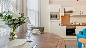 A modern kitchen with white cabinets, a microwave, and an oven. - 1 Bed in Tenby (oc-fb154) (Tenby)