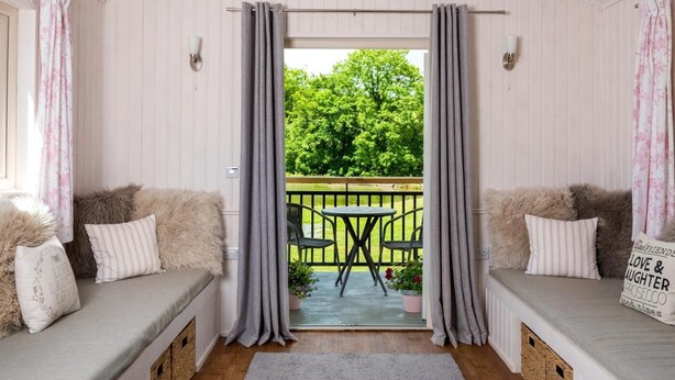 A cozy room with a bench seating area, a small table, and a view of a garden. - 1 Bed in Llangammarch Wells (oc-bn089) (Treflys)