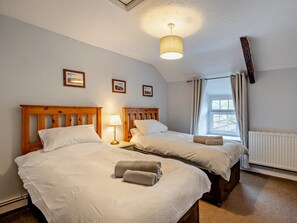 A hotel room with two beds, a ceiling light, a window with curtains, and framed pictures on the wall. - 2 Bed in Crickhowell (oc-bn052) (Llangynidr)