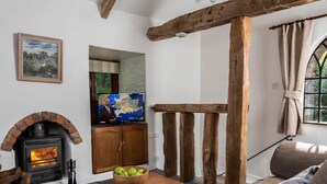 A cozy living room with a fireplace, a television, and rustic wooden beams. - 2 Bed in Brecon (oc-bn102) (Talybont-on-Usk)