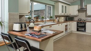 Una cocina con isla central, tostadora, hervidor y microondas.