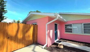 A pink house with a wooden fence, a door, and a window. - Flamingo House, Cozy 2/2 [pet friendly] (Sarasota)