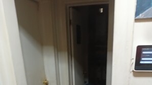 A narrow hallway with a wooden floor leading to a dark room. - Perfect 2-bedroom apartment with AC in charming Bronx neighborhood (Bronx)