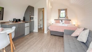 Ein kleines Schlafzimmer mit einem Bett, einem Nachttisch und einem Fenster.