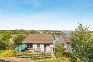 Ein Wohnhaus mit geneigtem Dach, einer sichtbaren Veranda und Blick auf das Meer.