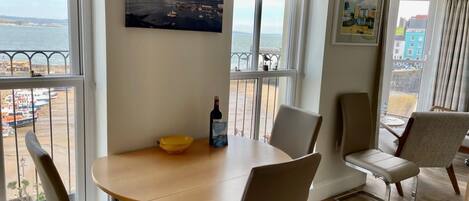 A dining area with a table, chairs, a bowl, and a bottle.