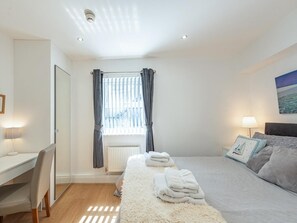 A bedroom with a bed, a desk, and a chair. - 2 Bed in Tenby (oc-fb114) (Tenby)