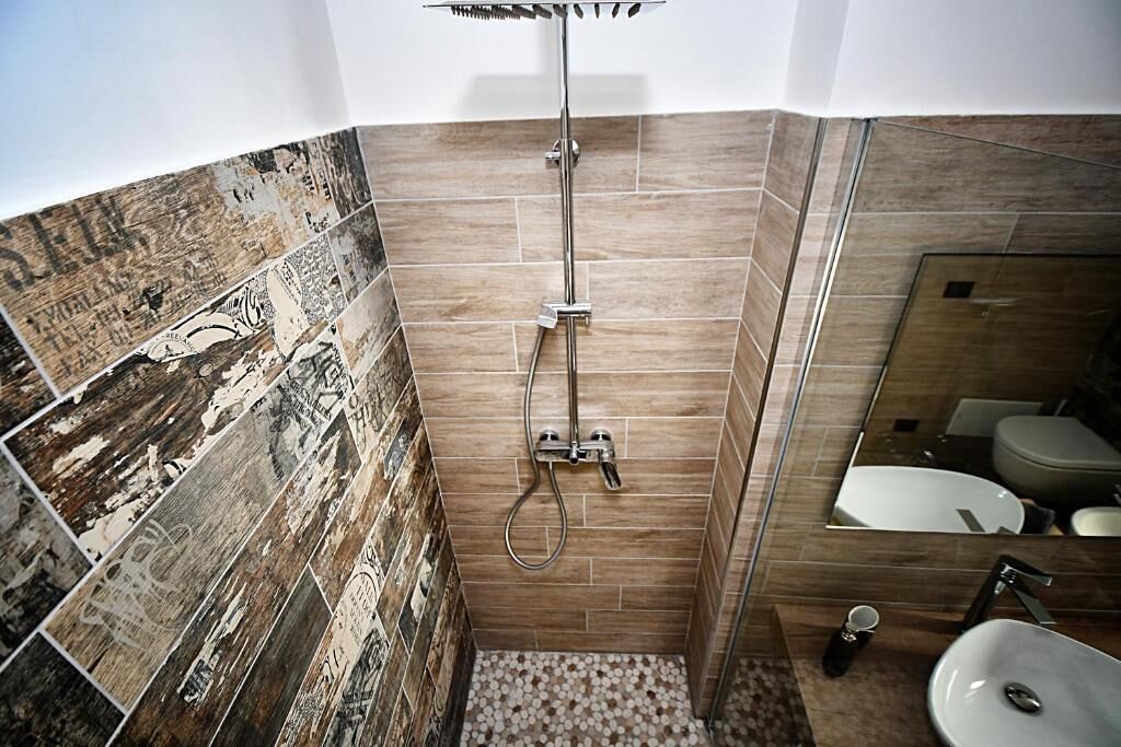 A bathroom with a shower, a sink, and a mirror.