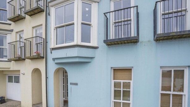 A row of townhouses with multiple windows and balconies. - 2 Bed in Tenby (oc-fb113) (Tenby)