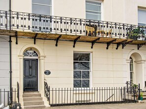 A building with a black door, a sign reading 'NEWTON CROFT,' and a balcony with a wrought iron railing. - 2 Bed in Tenby (oc-fb163) (Tenby)