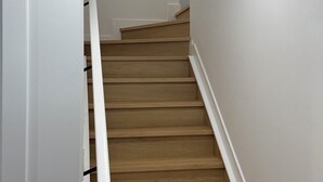 A wooden staircase with white walls and a handrail. - Spacious 2BR Suite|Near WEM|Families|Contractors (Edmonton)