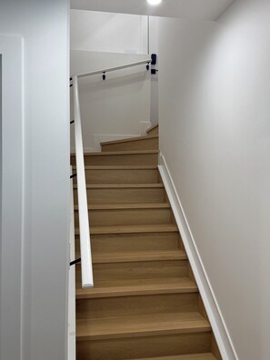 A wooden staircase with white walls and a handrail. - Spacious 2BR Suite|Near WEM|Families|Contractors (Edmonton)