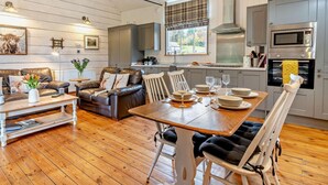 A modern kitchen with a dining area, wooden floors, and a cozy seating arrangement. - 2 Bed in Abergavenny (oc-bn246) (Pantygelli)